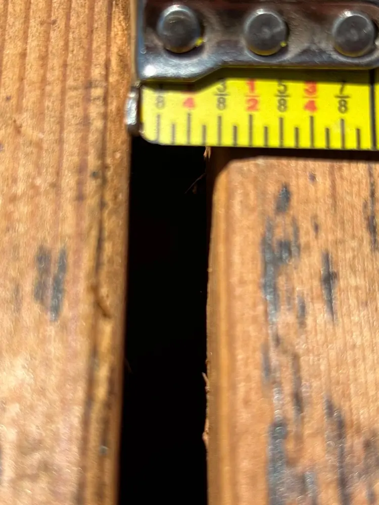 Tape measure documenting a wide gap between roof deck planks