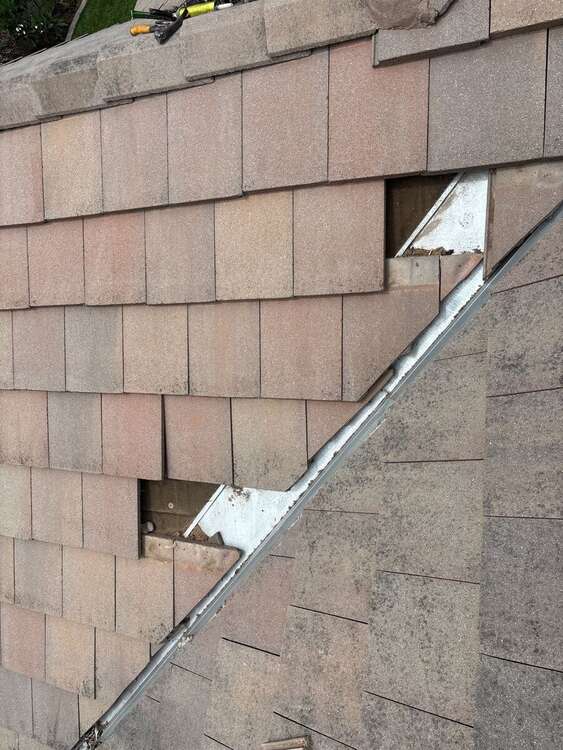 Tiles lifted at a roof valley with roof material exposed