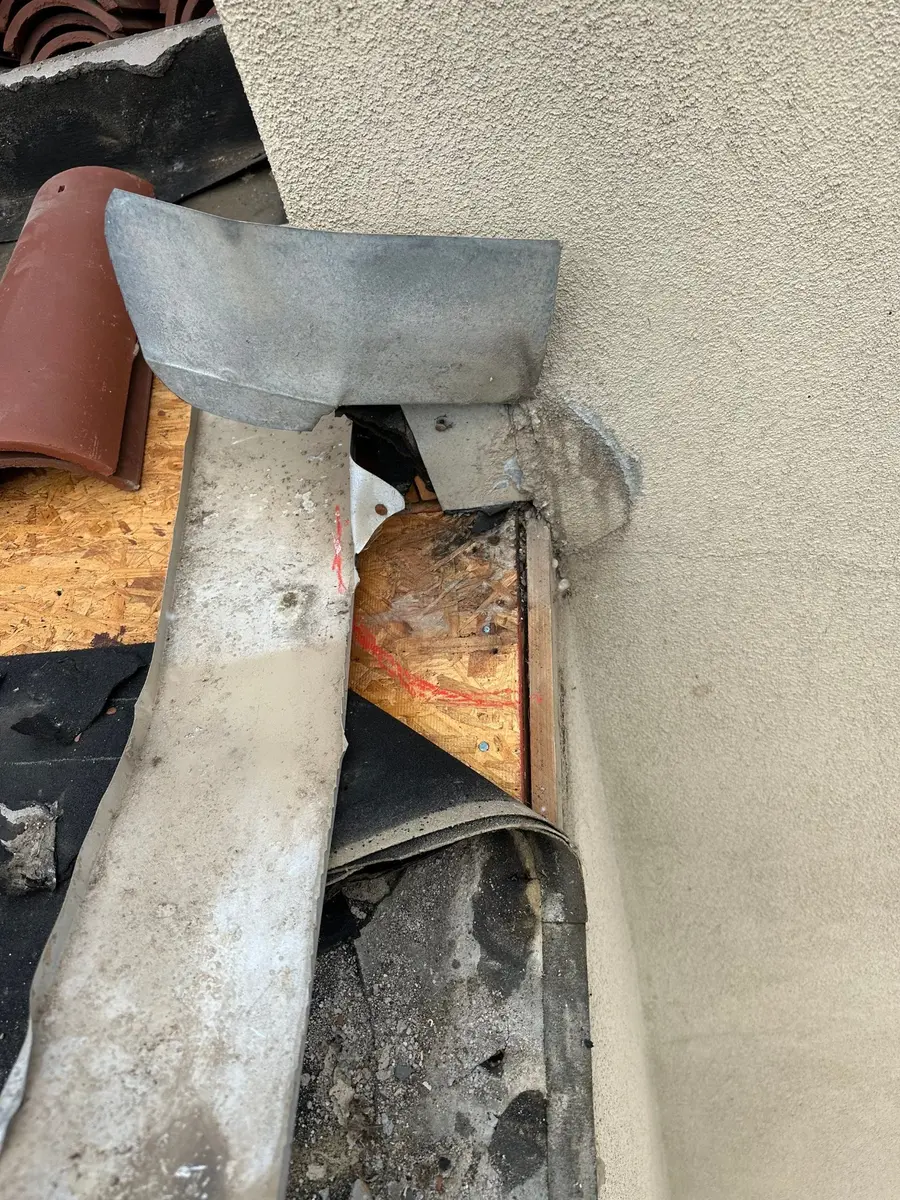 Failed clay roof sidewall flashing and exposed decking