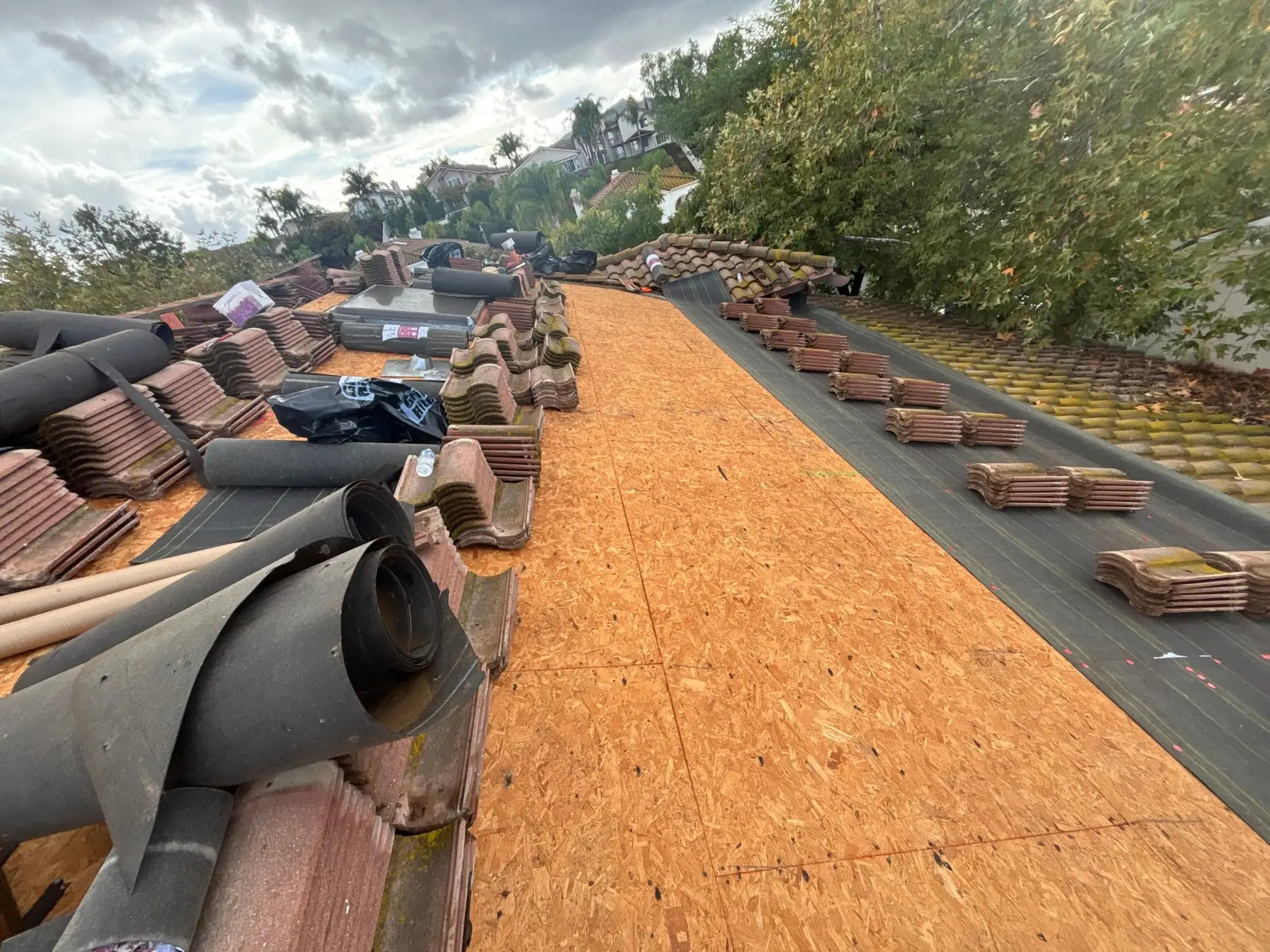 Tile roof deck replaced while reusable tiles are staged