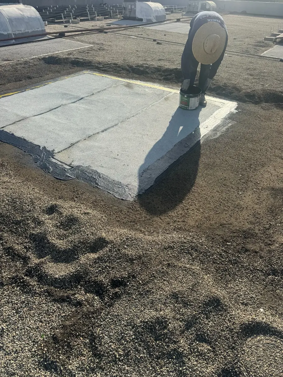 Zenith roofer working at a new built-up roof repair area surrounded by the existing gravel roof