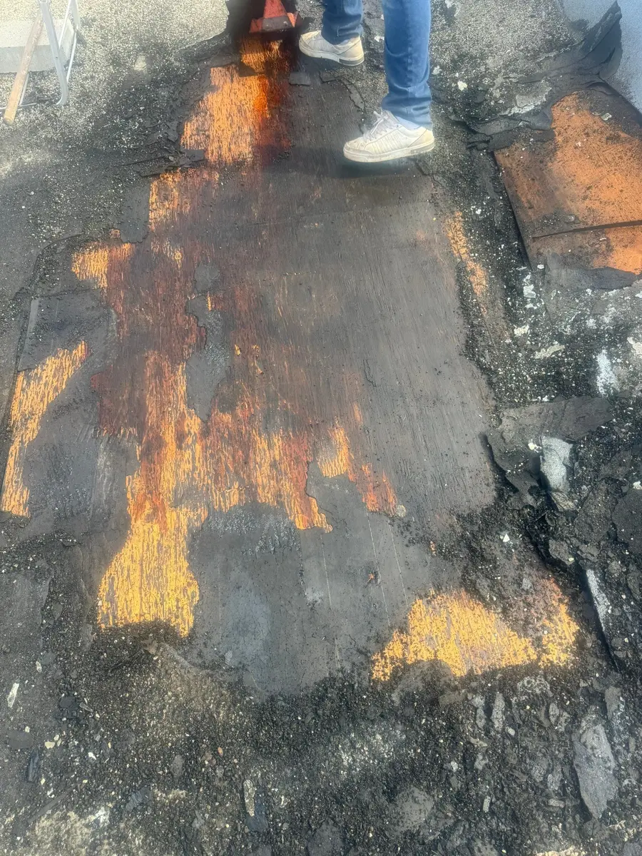 Built-up roofing removed to expose the aged roof deck and locate the repair area