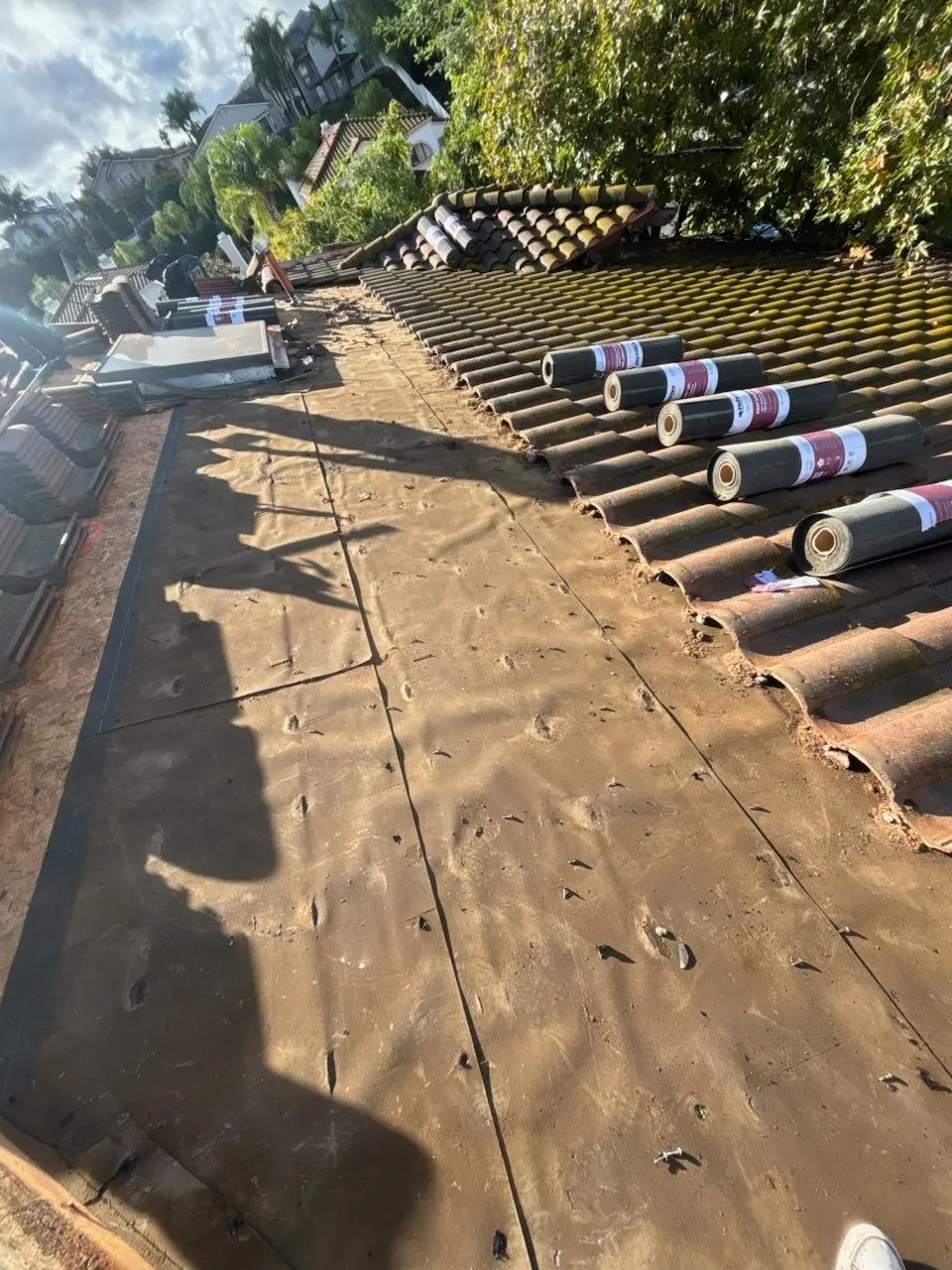 Old tile roof underlayment exposed after tiles were lifted
