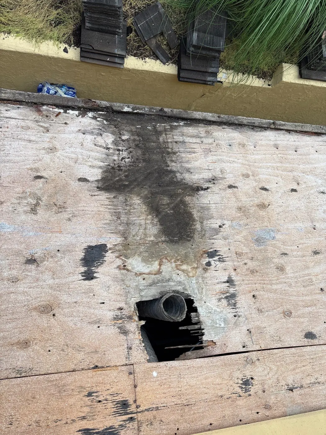 Localized damaged roof decking exposed around an existing pipe penetration