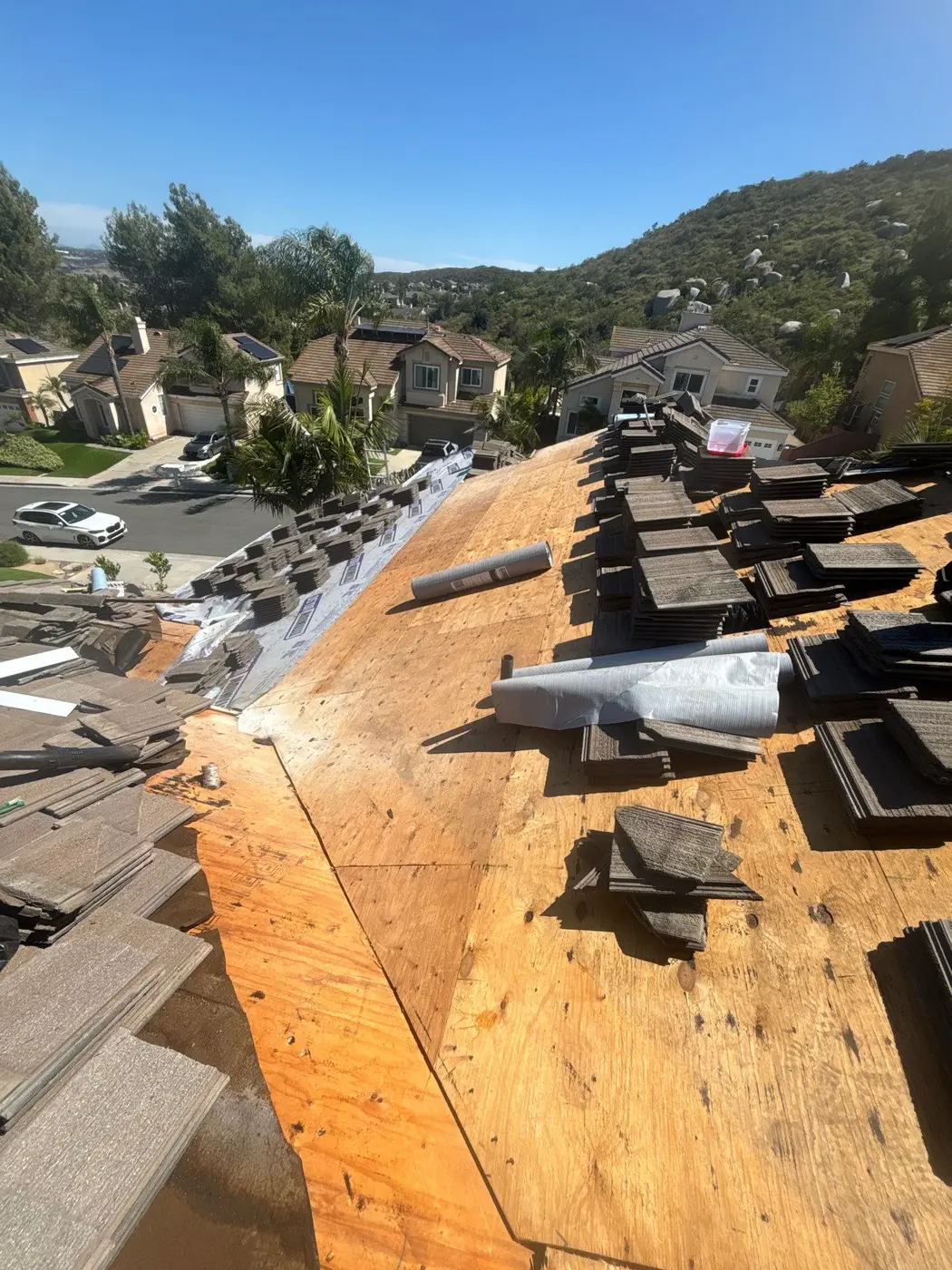 Prepared roof deck with existing concrete tiles stacked for reinstallation