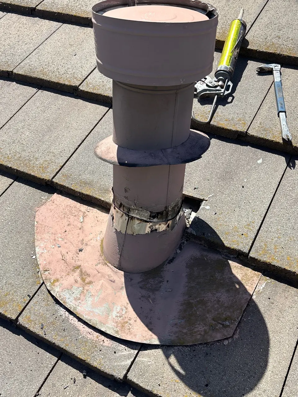 Aged sealant at a concrete tile roof vent penetration