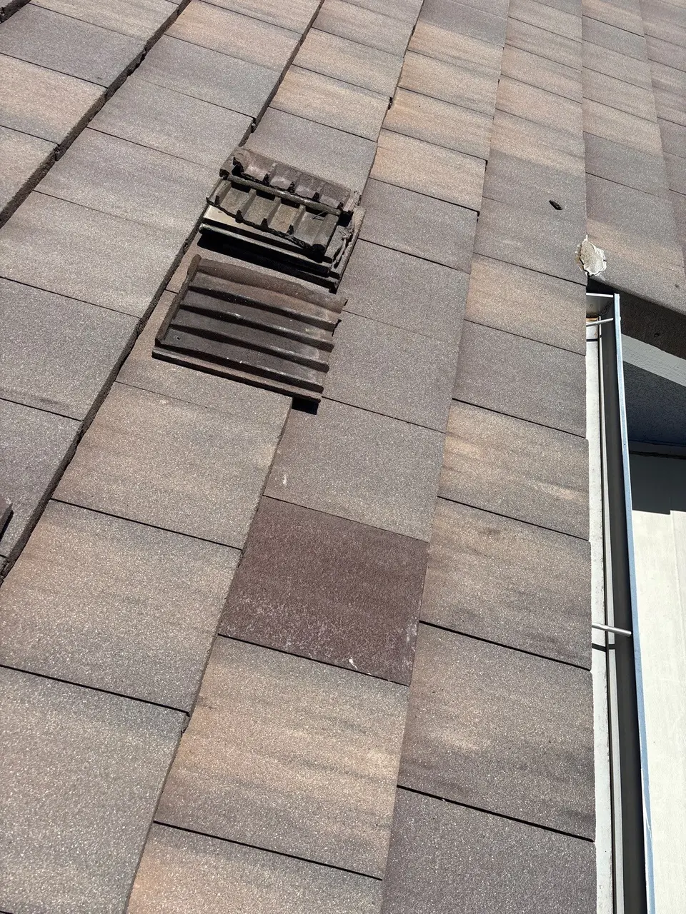 Concrete tiles opened around a vent pipe for flashing maintenance