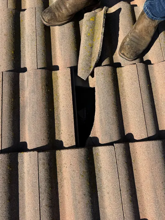 Missing and broken concrete roof tiles exposing underlayment