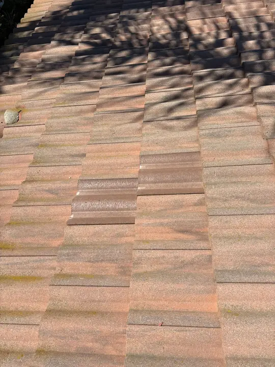 Slipped concrete roof tiles exposing the tile roof water-shedding assembly