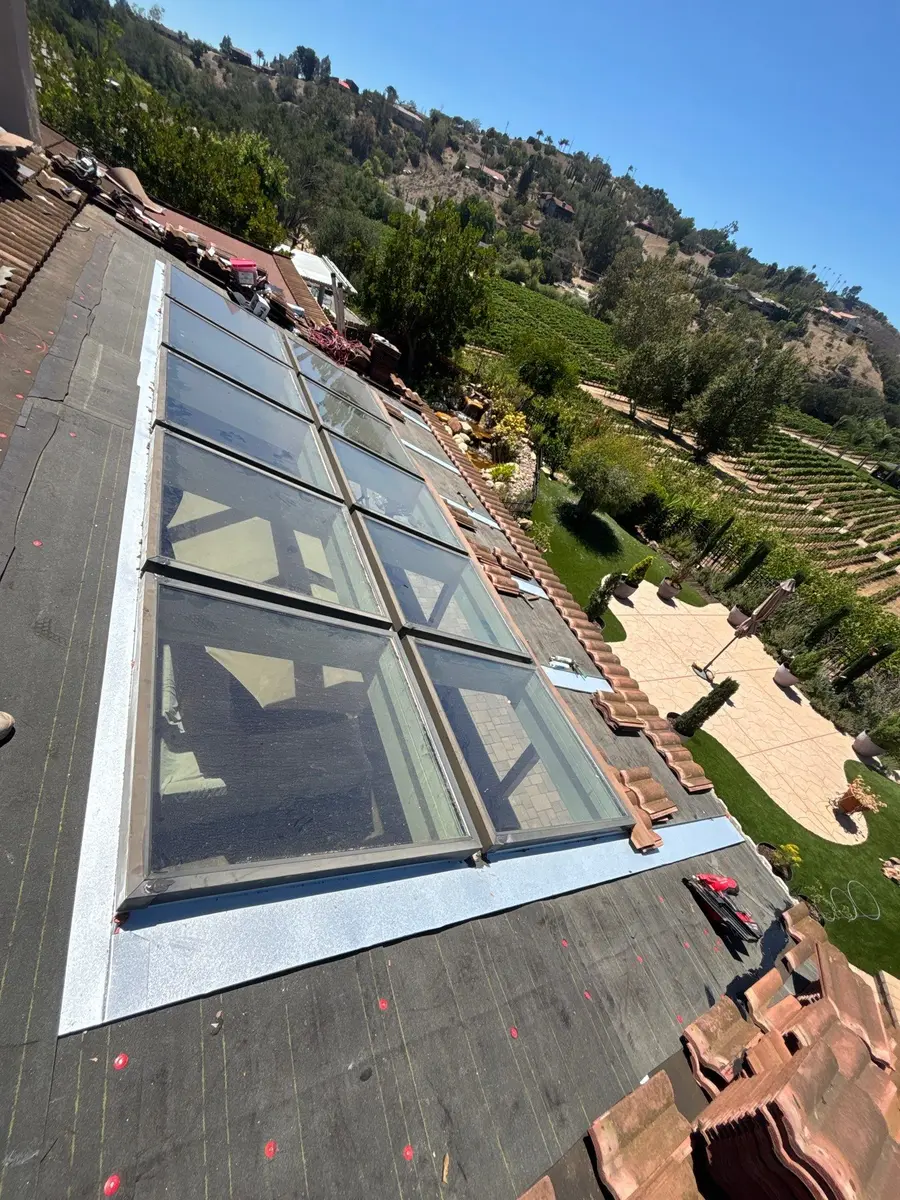 Large bank of skylights with surrounding concrete roof tiles removed