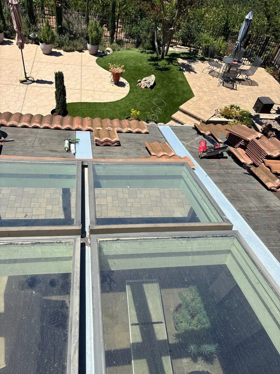 New metal flashing returning below a skylight bank on a tile roof