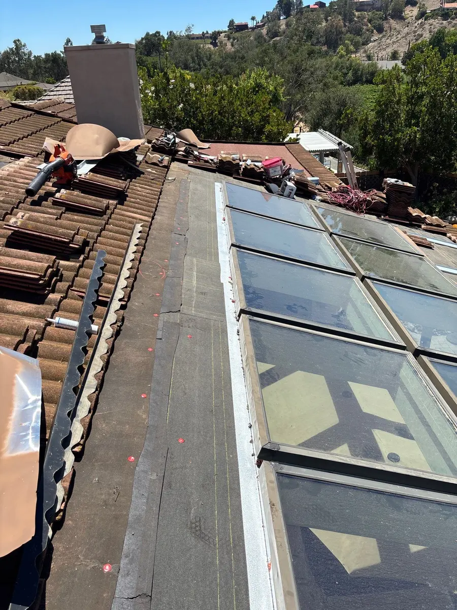 Exposed skylight side flashing and tile pans during a tile roof repair