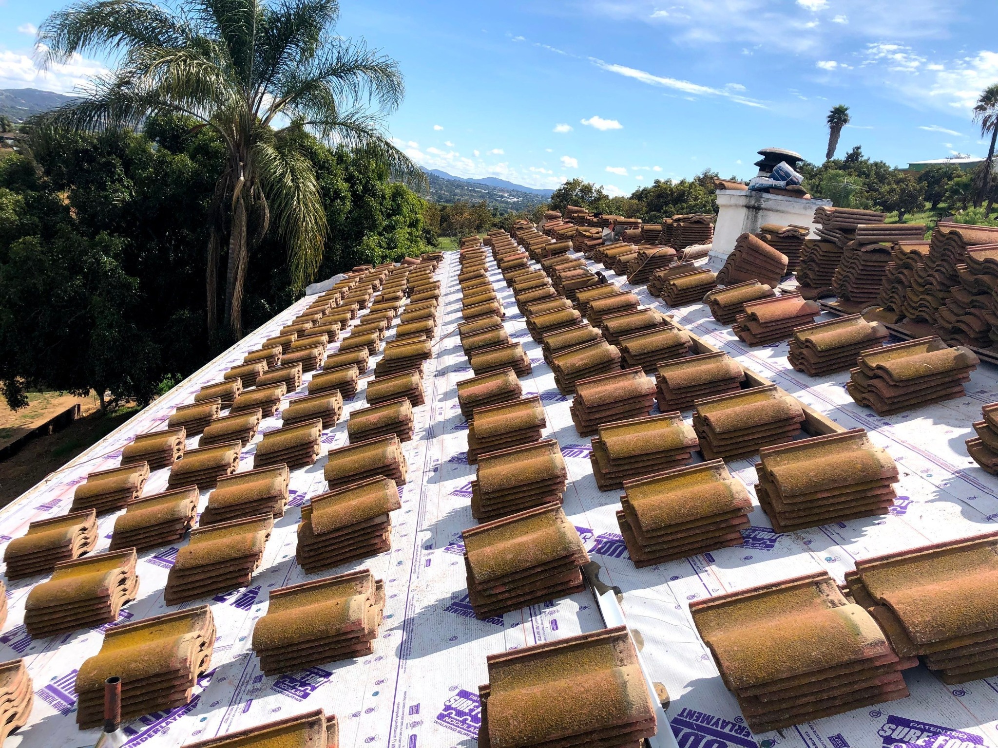 Roof tiles staged above new underlayment during a Zenith tile lift and lay project