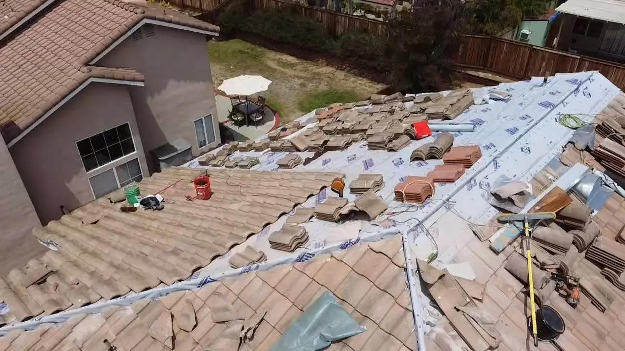 New underlayment installed while existing roof tiles are staged