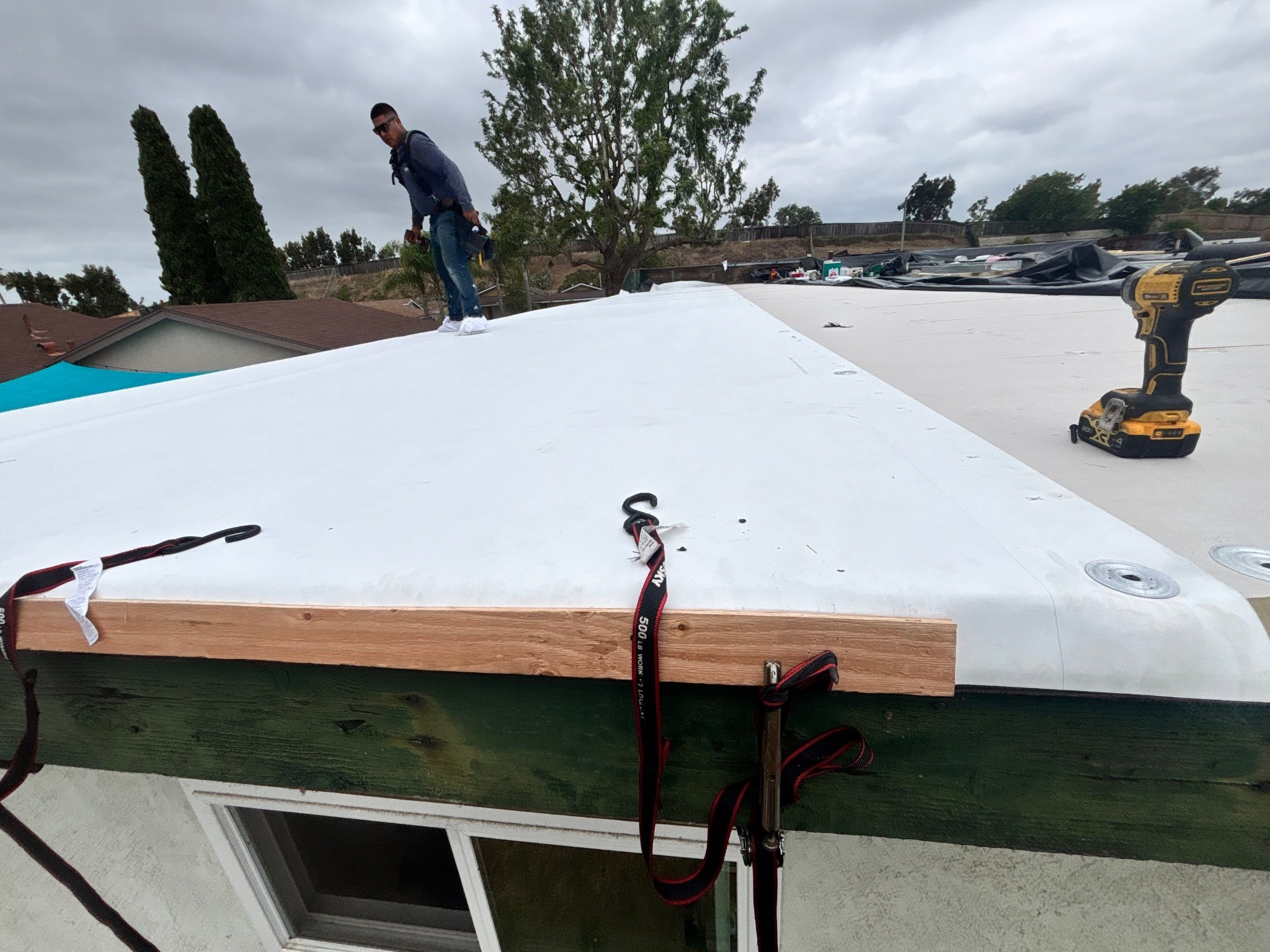 White TPO membrane being installed on a residential low-slope roof